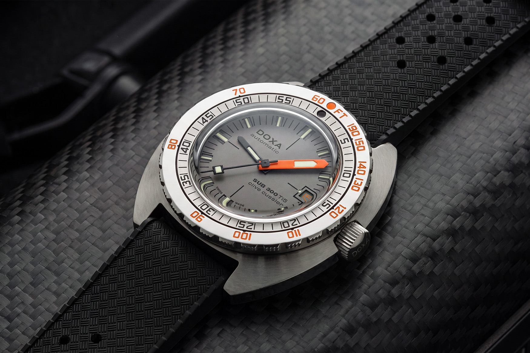 Close-up of the sandwich-construction titanium dial on the Doxa SUB 300 Ti5 Clive Cussler with laser-cut relief indices and the orange 15-7-31 date